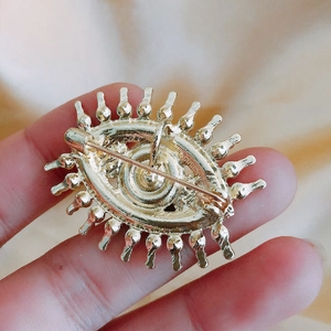 Vintage gold devil eye brooch with alloy metal texture and safe pin back closure