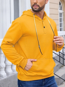 Detail of mustard yellow hoodie with textured herringbone fabric and buttoned neckline