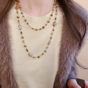 Detail of double-layer beaded necklace featuring vintage stones and gold plating