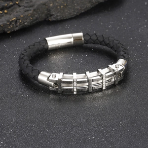Dettaglio macro del bracciale in pelle nera intrecciata con fibbia in zircone argento