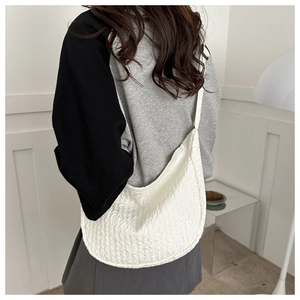 Fashionable white bubble textured crossbody bag shown on a model with minimalist outfit