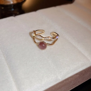 Detailopname van de dubbellaagse gouden ring met paarse kattenoogsteen en glinsterende zirkonia