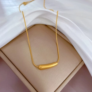 Nahaufnahme eines Goldstab-Anhängers an einer Schlangenkette in einer edlen Box