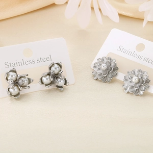 Detail of silver stainless steel flower earrings with pearls and intricate petal textures