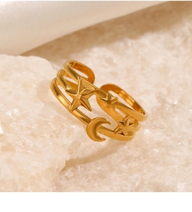 Detail of gold-plated triple layer ring with star and moon charms on mineral stone