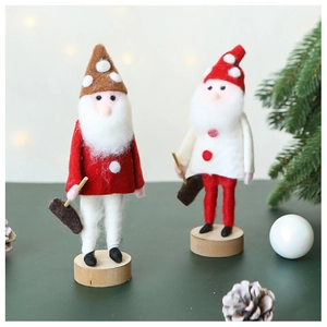 Detail of wool felt Christmas gnomes with wooden bases in a cozy festive setting