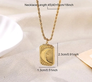 Detailed view of golden rectangle pendant with crescent moon and sunray engraving