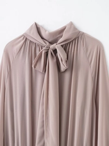 Detail of the bow tie neckline and soft pleats on a dusty pink chiffon dress