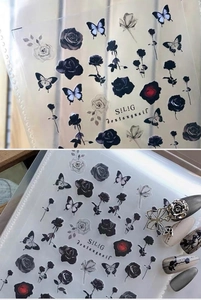 Macro detail of gothic dark rose and butterfly adhesive nail art stickers on transparent film