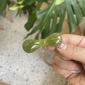 Detailed view of an olive green jelly resin hair clip with gold Barrette La France text