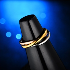 Luxury tricolor interlocking titanium steel rings on display with elegant bokeh background
