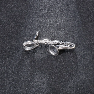 Detailed view of silver saxophone musical instrument pendant in polished stainless steel