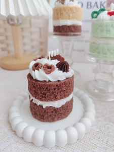 Macro shot of a double-layered chocolate sponge cake candle with cream and biscuits