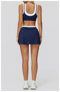Detail of navy yoga set showing racerback sports bra and skirt with white contrast trim