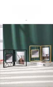 Detail of a minimalist gold metal folding photo frame on a soft white plush rug background