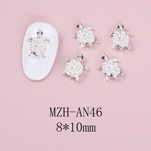 Detailed macro view of 8x10mm silver turtle nail art charms with white faux pearls