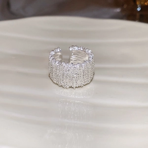 Detailed close-up of wide silver ring featuring a textured crushed metal surface design