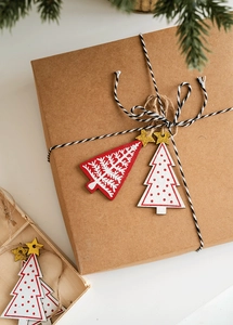 Close-up of wooden Christmas tree ornaments with gold stars on a gift box