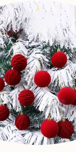 Macro detail of red flocked Christmas ornaments with diverse textures on snow-covered tree