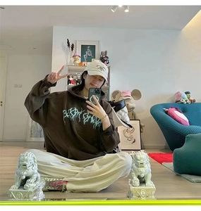 Mirror selfie showing oversized dark brown hoodie with green lightning graphics