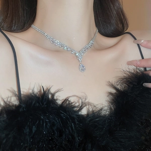 Detail of silver Y-shaped necklace with teardrop zircon pendant on a model's neck