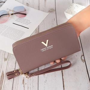 Detail of mauve faux leather clutch featuring double zipper and detachable wrist strap
