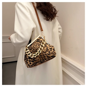 Detail view of leopard print handbag with chunky gold chain strap and metal frame closure