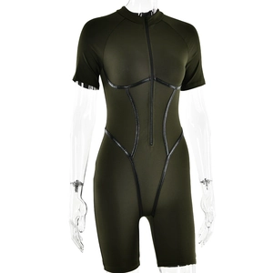 Detailed close-up of a green athletic romper featuring black piping and a front zipper