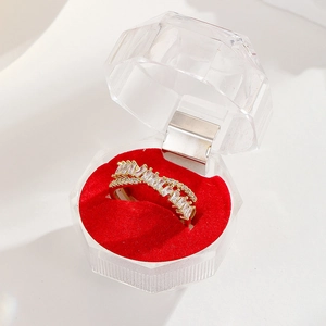 Detail of 18K gold-plated crisscross ring with zircons on a red velvet jewelry box