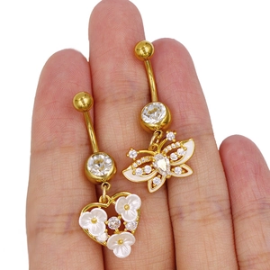 Detaillierte Nahaufnahme von goldenen Schmetterlings- und Herz-Bauchnabelpiercings