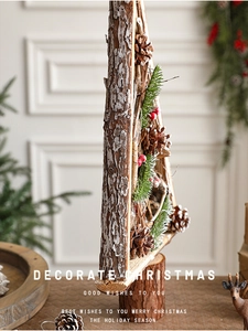 Detail of wooden Christmas tree with natural bark, pine cones, and berries on wood base