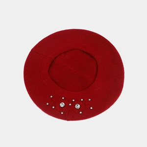 Detailed view of dark red beret with intricate floral embroidery and sparkling rhinestones