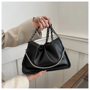 Detail of black pleated cloud bag featuring dual leather-wrapped and metal chain straps