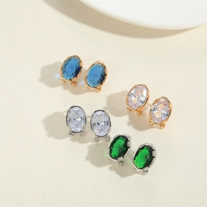 Detailed view of oval crystal stud earrings in blue green and white on beige background