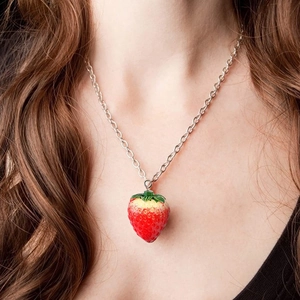Detailed close-up of a realistic resin strawberry pendant on a silver necklace chain