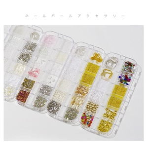 Assorted nail art decoration kit with pearls, rhinestones and metal charms in a storage box
