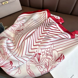 Detailed close-up of red and white floral silk scarf texture on leather surface