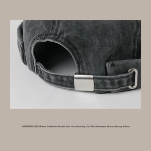 Detail of dark grey washed cotton bucket hat with adjustable silver metal buckle and texture