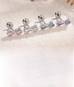 Macro detail of bow-shaped zircon earrings with titanium steel screw back specifications