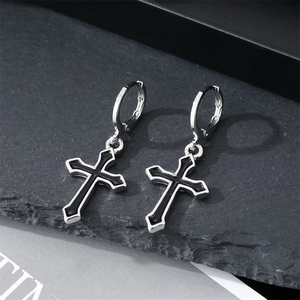 Punk style silver hoop earrings with black cross pendants on a gray stone surface