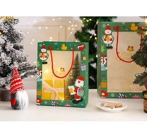 Detail of green Christmas gift bag with transparent window and Santa Claus illustration