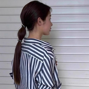 Detail view of stylish high-elastic hair tie with shiny silver spheres on a ponytail