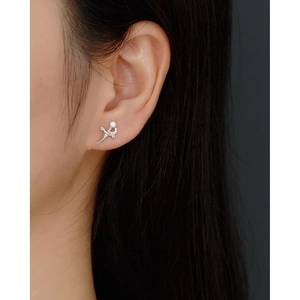 Close-up of S925 silver dagger stud earring with sparkling crystals on ear cartilage