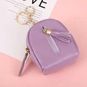 Detailed macro of a purple mini backpack coin purse with tassel and lychee texture