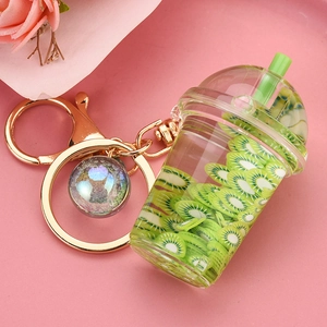 Detail of creative kiwi fruit tea cup keychain with golden clasp and iridescent bead