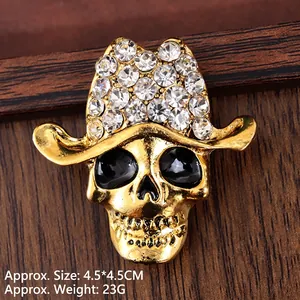 Retro golden skull brooch with cowboy hat and sparkling crystals on wooden background