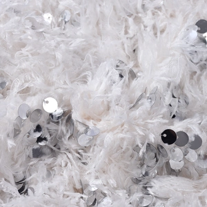 Close-up of white feather-like fabric with shimmering silver sequins on sexy crop top set