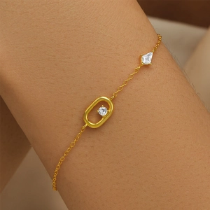 Close-up of a gold-plated S925 silver bracelet featuring oval and rhombus charms with cubic zirconia