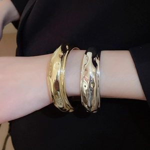 Détails de larges bracelets ouverts avec texture martelée dorée et argentée polie