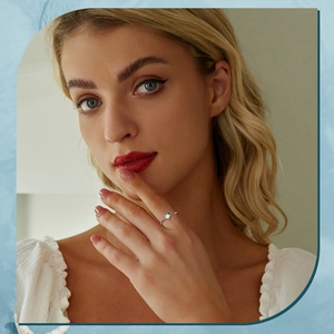 Detail of s925 silver sea turtle ring with white opal worn by a model in soft lighting